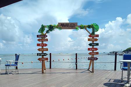 Scenic dock with directional signs for various water activities at NomadicStan. Perfect for beachgoe.