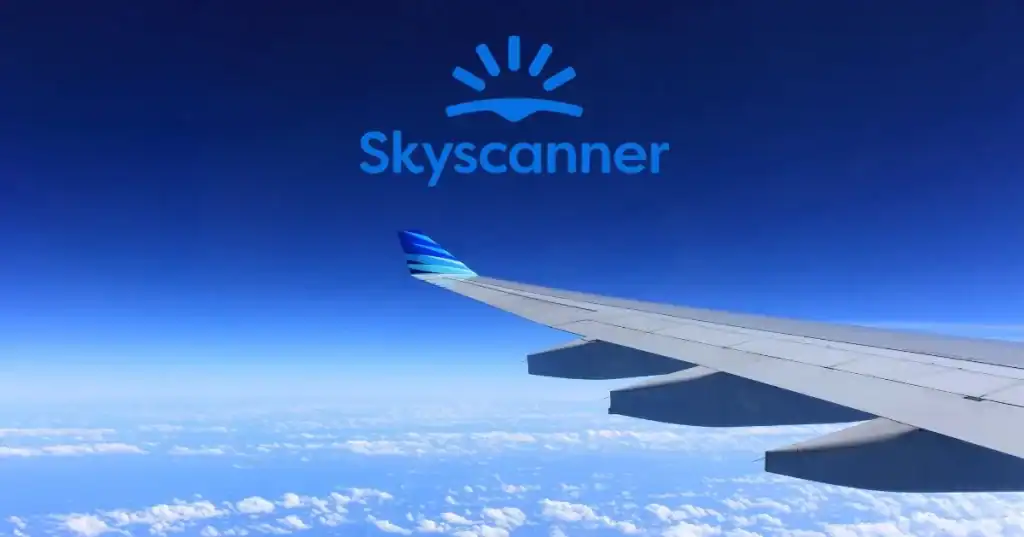 Skyscanner airplane wing view over clouds and sky.