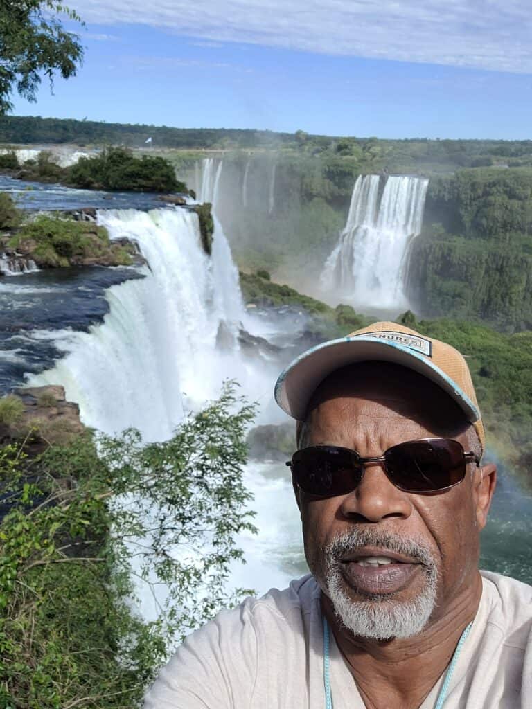 NomadicStan enjoying Niagara Falls view with sunglasses and cap.