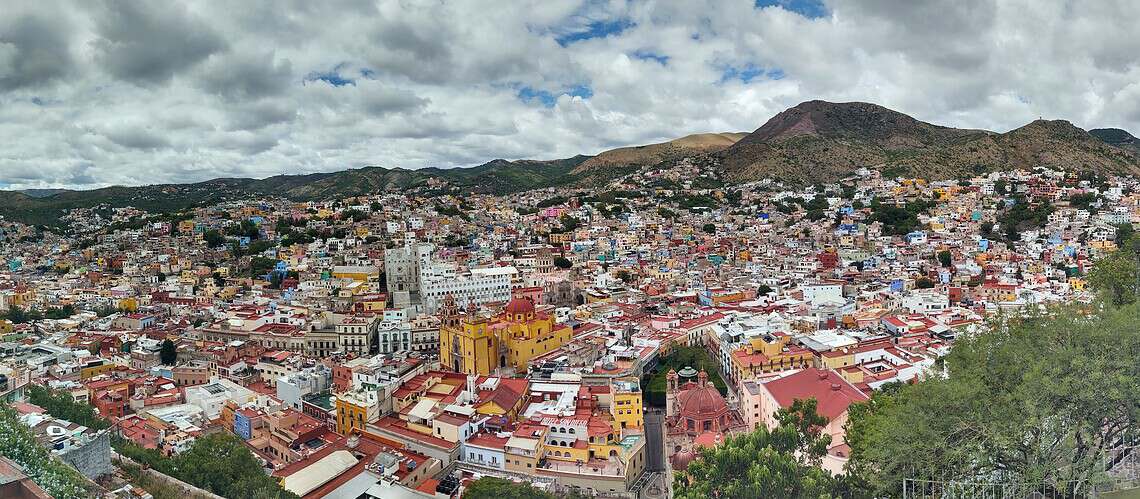 A vibrant view of Mexico City with colorful buildings and mountains in the background.