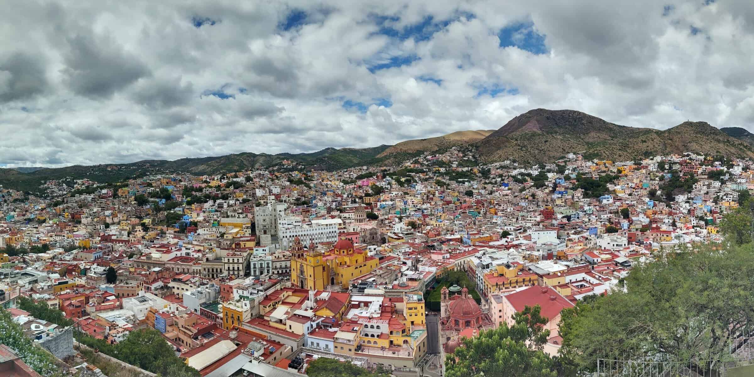 A vibrant view of Mexico City with colorful buildings and mountains in the background.