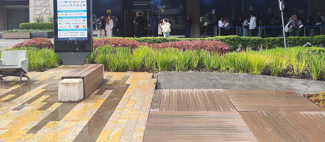 Contemporary office building with reflective glass facade and outdoor seating area.