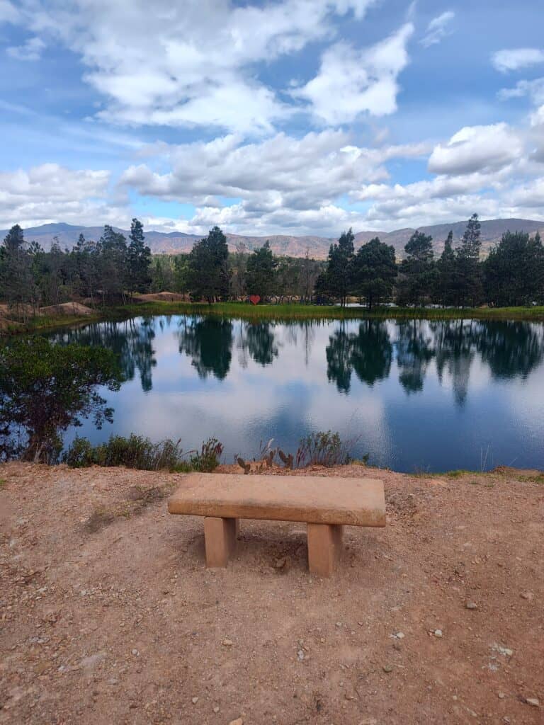 Beautiful lake surrounded by trees under a partly cloudy sky.